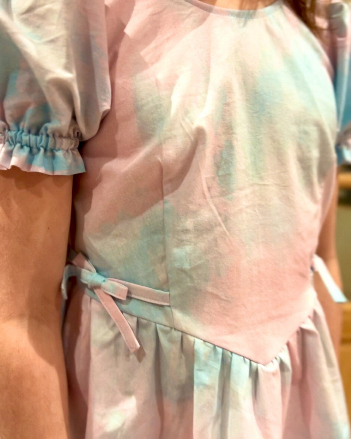 Pastel-colored dress with a tie waist on a blurred background