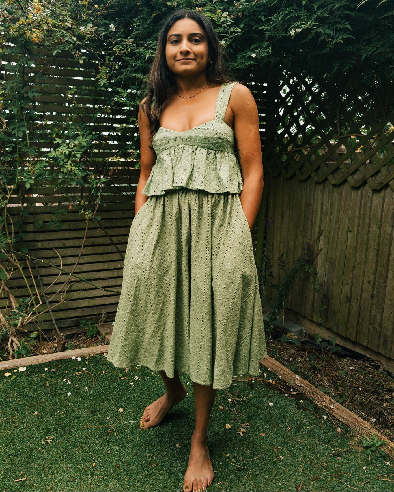 Woman in a green dress standing in a garden