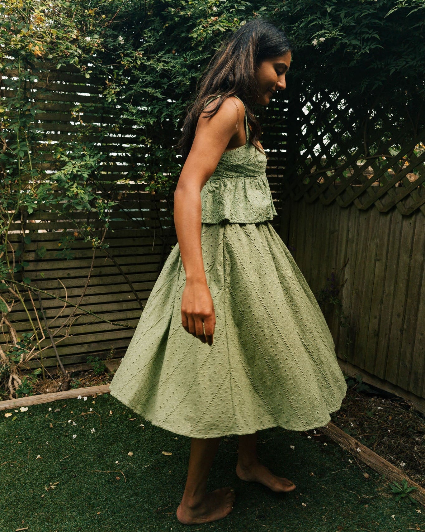 Woman in a green dress standing in a garden