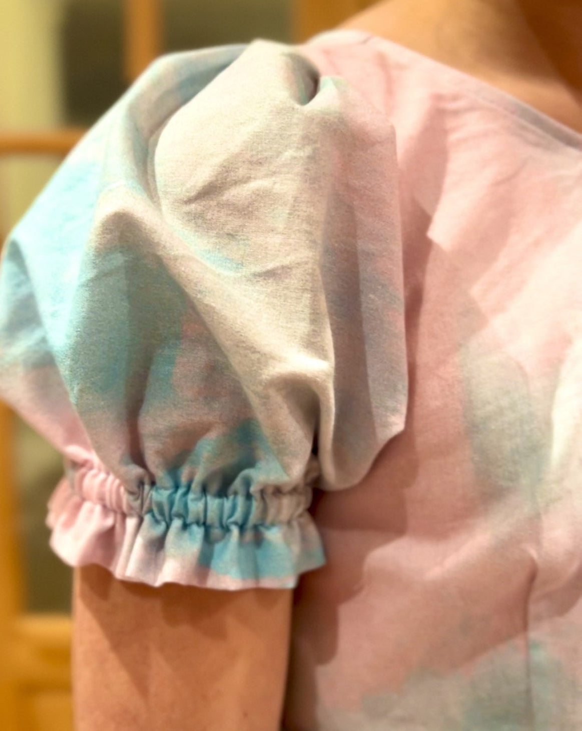 Close-up of a person wearing a colorful outfit with a focus on the sleeve and shoulder area.