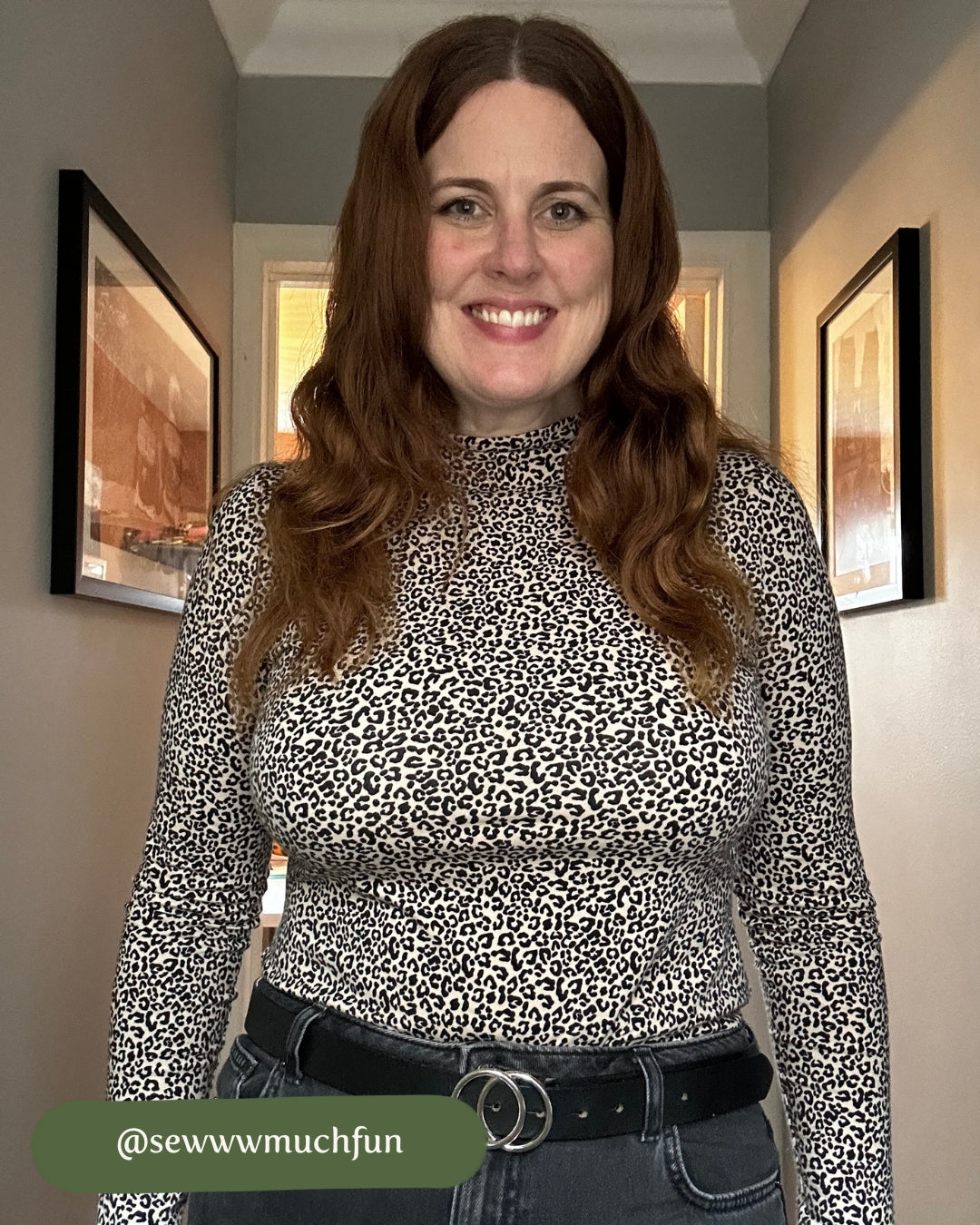 Woman wearing a leopard print top in a room with framed pictures on the wall.