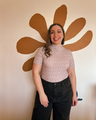 Woman standing in front of a large brown flower wall decoration